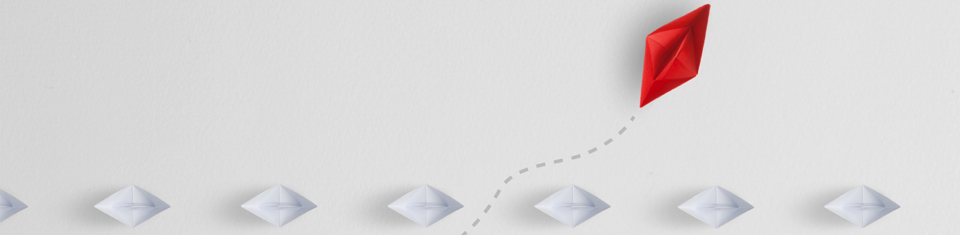 A red paper plane flying ahead of a row of white paper boats on a white background, depicted with a dashed trail indicating its movement.