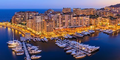 A marina filled with boats docked at dusk, creating a serene and picturesque scene by the water's edge.