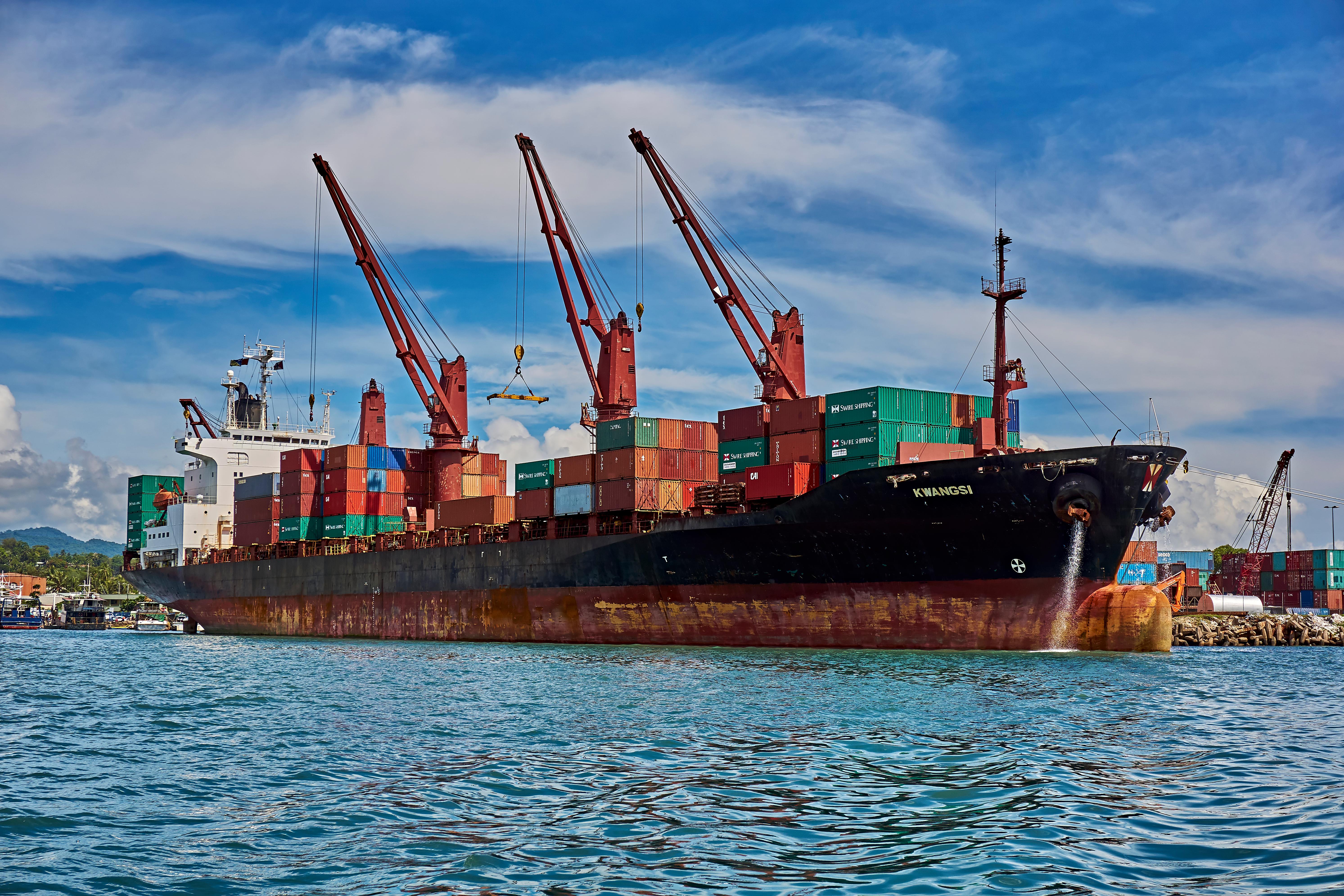 A large container ship loaded with cargo navigates through the water, showcasing its impressive size and capacity.