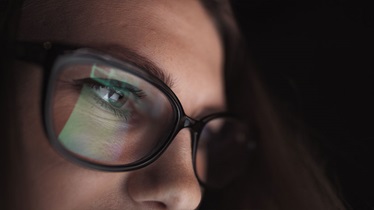 girl looking at computer reflection in glasses