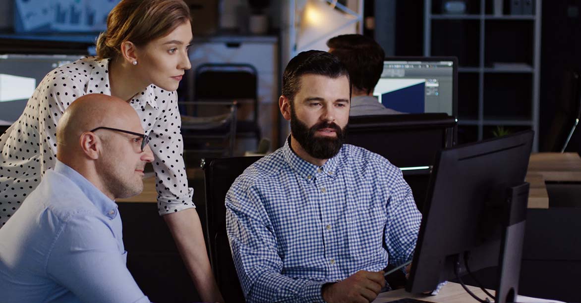 Professionals crowded round a laptop