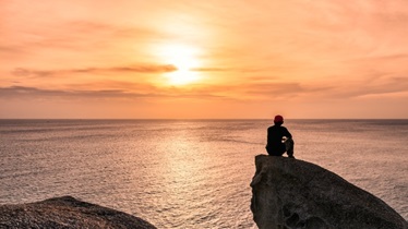 man sitting on rock