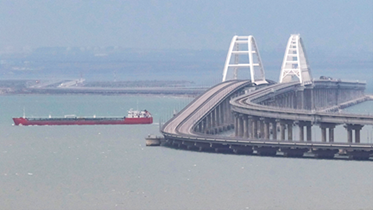 A massive vessel passing over a bridge.